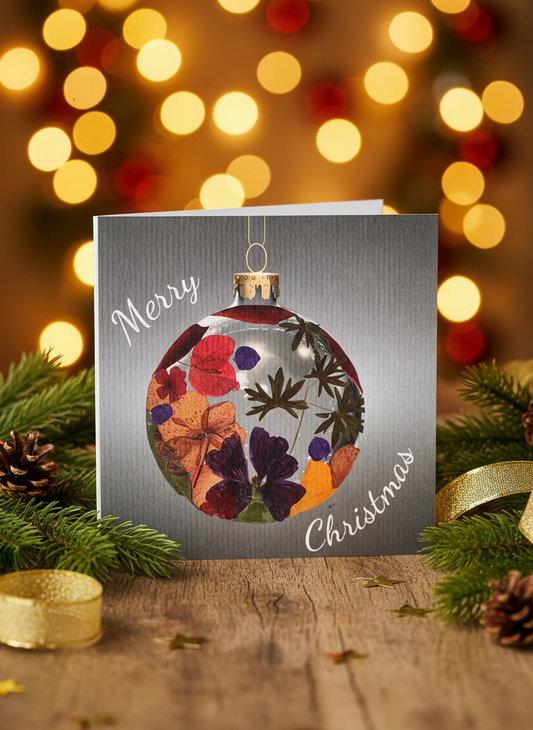 Christmas card with a decorative glass ornament featuring pressed flowers and the text 'Merry Christmas'.